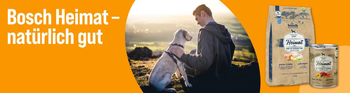 Entdecke Bosch Heimat Aktionsbanner mit Bosch Heimat Hundefutterprodukten und einem Hund in einer Natur‑Szene.