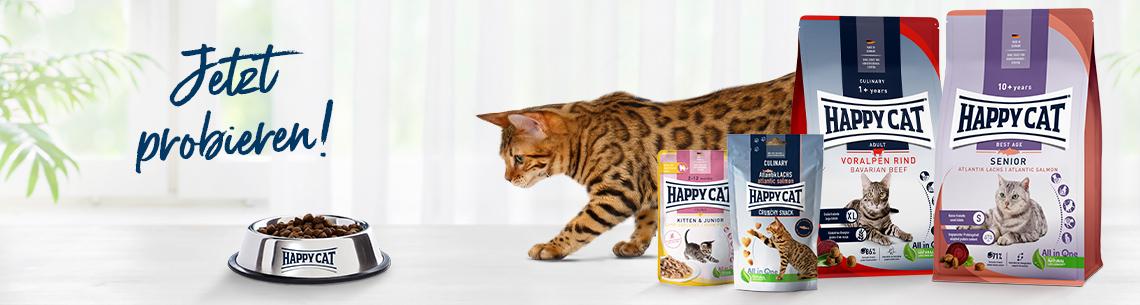 Happy Cat Katzenfutter Aktionsbanner für Happy Cat Katzenfutter. Links der Schriftzug „Jetzt probieren!“ vor hellem Hintergrund. Mittig eine gefleckte Katze neben einem Futternapf. Rechts ein Qualitätssiegel „Deutscher Kunden Award 2025/26“ sowie verschiedene Happy Cat Produkte, darunter Trocken- und Nassfutter. Hinweis: Helles Markenmotiv mit Fokus auf Produkttest, Auszeichnung und Katzennahrung.