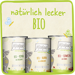 MjAMjAM Bio Hund Drei Dosen MjAMjAM‑Bio‑Hundefutter verschiedener Sorten vor hellem Hintergrund.