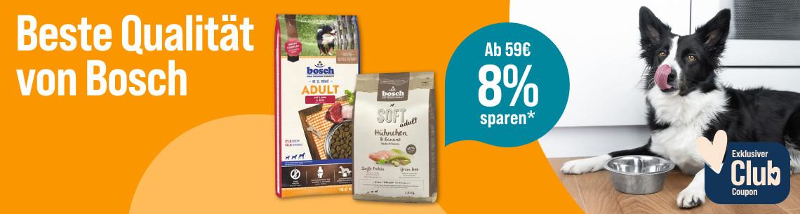 Spare 8% ab 59€ auf Bosch Hundefutter Aktionsbanner für Hundefutter von Bosch. Hund liegt neben einem Futternapf in einer Küche, daneben Verpackungen von Trockenfutter.