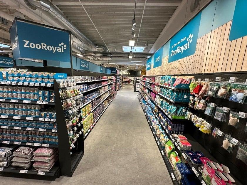 ZooRoyal Shop in Shop Heller Gang im ZooRoyal‑Markt mit voll bestückten Regalen für Tierfutter, Zubehör und Pflegeprodukte.