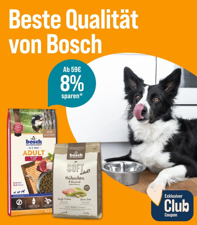 Spare 8% ab 59€ auf Bosch Hundefutter Aktionsbanner für Hundefutter von Bosch. Hund liegt neben einem Futternapf in einer Küche, daneben Verpackungen von Trockenfutter.