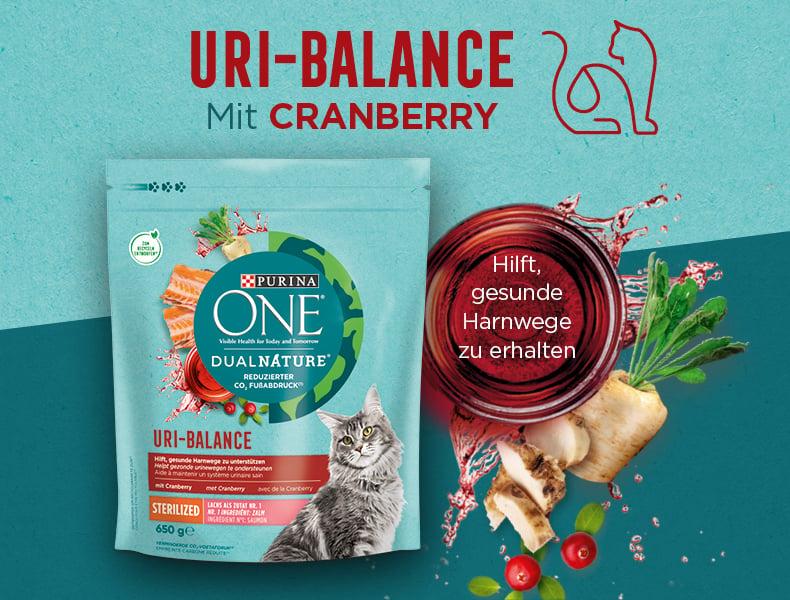 Purina ONE Uri Balance Purina‑ONE‑Uri‑Balance‑Beutel neben Cranberry‑Zutaten und dem Hinweis auf Unterstützung der Harnwege.